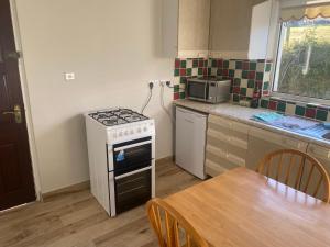 a small kitchen with a stove and a table at Sea View Cottage in Clonmany