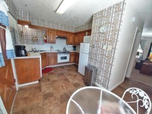 una cucina con armadietti in legno ed elettrodomestici bianchi di Valley Condo 101 Creekside - End Unit - Wi-Fi - Hot Tub - Fireplace - Washer - Dryer - Playground a Red River