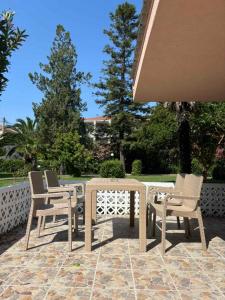 a patio with a table and chairs on a patio at Garden Haven 100m from the Sea in Siviri