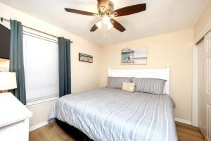 ein Schlafzimmer mit einem Bett und einem Deckenventilator in der Unterkunft Shelly Sands HeatedPool & HotTub Private Beach in Destin