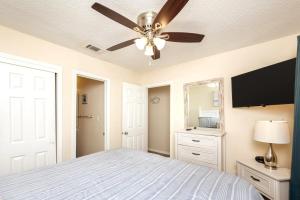 ein Schlafzimmer mit einem Bett und einem Deckenventilator in der Unterkunft Shelly Sands HeatedPool & HotTub Private Beach in Destin