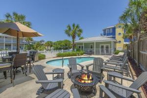 un patio con sillas, mesas y una hoguera en Crystal Tower Free Golf Cart Private Pool, en Destin