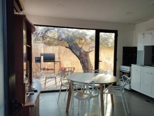 a kitchen with a table and chairs and a tree at Takú Huasi in La Rioja