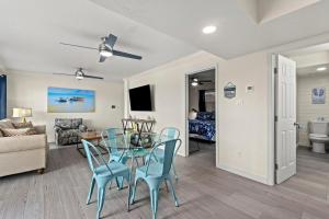 a living room with a glass table and blue chairs at Hook Line Double Sinker Lake View 3 Comm Pools in Destin