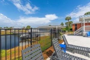 a fence with two benches next to a body of water at Hook Line Double Sinker Lake View 3 Comm Pools in Destin