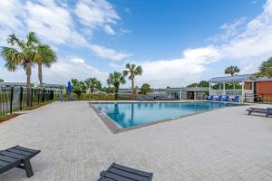 a swimming pool with two benches and palm trees at Hook Line Double Sinker Lake View 3 Comm Pools in Destin