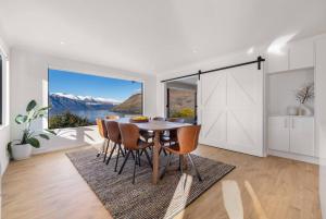 une salle à manger avec une table et une grande fenêtre dans l'établissement Fabulous Home with Great Views, à Queenstown