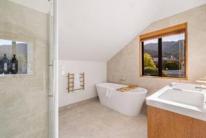 une salle de bain avec une baignoire et un lavabo dans l'établissement Fabulous Home with Great Views, à Queenstown 22 autres photos