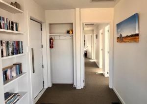 a hallway with white walls and shelves with books at Shepherd's View - Lake Tekapo in Lake Tekapo