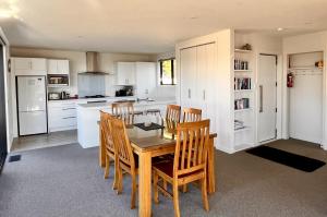 a kitchen with a wooden table and chairs in it at Shepherd's View - Lake Tekapo in Lake Tekapo