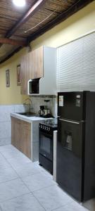 a kitchen with a stove and a microwave at Departamentos las Palmeras in Tarapoto