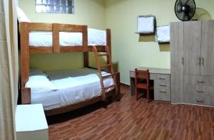 a bedroom with two bunk beds and a desk at Departamentos las Palmeras in Tarapoto