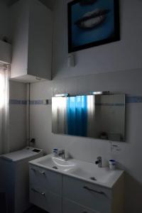 a bathroom with a sink and a mirror at Appartement charmant à Le Gosier avec vue sur la mer, 110 m² in Le Gosier +12 photos