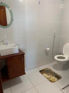 a bathroom with a sink and a toilet and a mirror at Chalés Pulo do Gato in Canoa Quebrada +61 photos