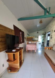 un salon avec une télévision et une table dans l'établissement Casa ampla e muito arborizada!, à Prado
