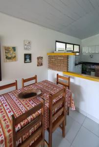 une salle à manger avec une table et des chaises et une cuisine dans l'établissement Casa ampla e muito arborizada!, à Prado 16 autres photos