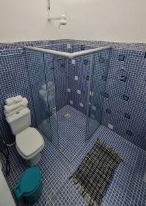 a blue tiled bathroom with a toilet and a shower at Casa ampla e muito arborizada! in Prado