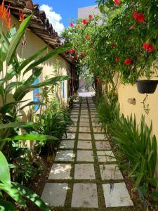 an alleyway in a garden with flowers and plants at Chalés Pulo do Gato in Canoa Quebrada