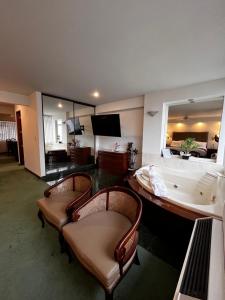 a living room with a bath tub and two chairs at Hotel Boulevard in Lima