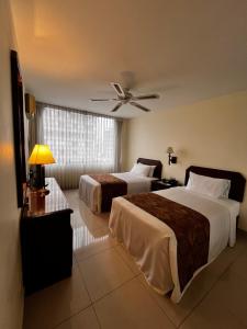 a hotel room with two beds and a ceiling fan at Hotel Boulevard in Lima