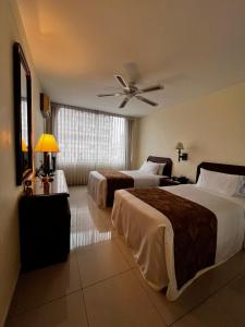 a hotel room with two beds and a ceiling fan at Hotel Boulevard in Lima