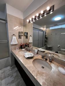 a bathroom with two sinks and a large mirror at Hotel Boulevard in Lima