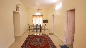 a living room with a table and a rug on the floor at Kannadisseril Windy Homes in Vagamon