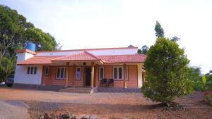 a small house with a red roof at Kannadisseril Windy Homes in Vagamon
