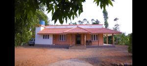 a small house with a red roof at Kannadisseril Windy Homes in Vagamon