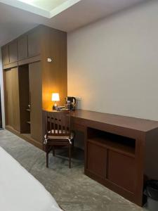 Una habitación con un escritorio con una lámpara y una silla. en Mokkwa Mansion, Hat yai, en Hat Yai