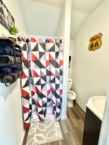 a bathroom with a checkered shower curtain at Route 66 Pop Stop-Minutes to Main St in Bandera +33 photos