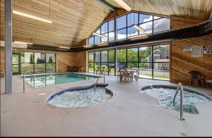 a pool in a house with a large room with windows at NEW- Lovely 2-Bdr2Bath Gatlinburg Condo with resort indoor pool hot tub Wi-fi, great location in Gatlinburg