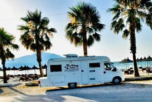 a white trailer parked on the beach with palm trees at Camper Van For Rent in Tirana +9 photos