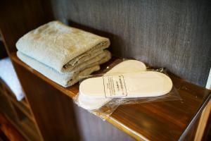 a shelf with towels and a hair dryer on it at 奄美ゲストハウス矢之脇町-Amami Guesthouse Yanowakicho- in Amami +18 photos