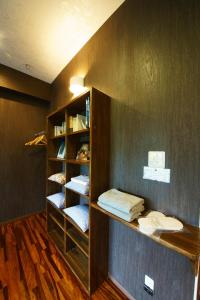 a book shelf with folded towels in a room at 奄美ゲストハウス矢之脇町-Amami Guesthouse Yanowakicho- in Amami
