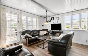 Il comprend un salon doté d'un mobilier en cuir et d'une télévision à écran plat. dans l'établissement 4 Bedroom Gorgeous Home In Hemmet, à Hemmet