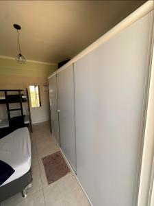 a bedroom with a sliding door and a bed at Pousada Vitória Régia Olímpia in Olímpia
