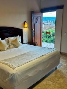 a bedroom with a large bed with a large window at Parador Margarita in San Crist&oacute;bal de Las Casas