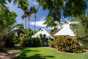 a house with palm trees in front of a yard at Kellys Beach Resort in Bargara