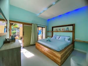 吉利阿尔Marta House gili air的卧室里有一张大床，墙壁是蓝色的