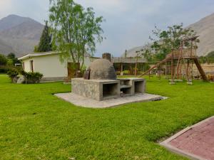 a stone bench in a yard with a playground at Rio Lindo Ecolodge in Lunahuaná