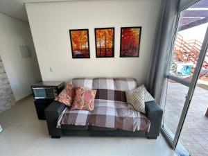 a couch in a living room with paintings on the wall at Pousada Vila das Grutas in João Pessoa
