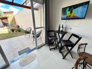 a living room with a tv and a table and chairs at Pousada Vila das Grutas in João Pessoa