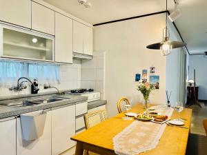 a kitchen with a wooden table and a kitchen with white cabinets at Nerja in Seoul