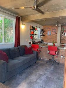 a living room with a couch and two red chairs at Villa Palmas #1 One bedroom beach scape apartament in San Francisco