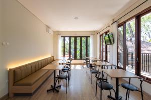 a row of tables and chairs in a room with windows at Fazza Homes in Surabaya
