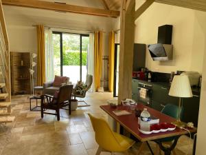 una cucina e un soggiorno con tavolo e sedie di Échappez-vous à la campagne sarthoise: charme, nature, proximité 24H du Mans & zoo! - FR-1-410-448 a Mayet