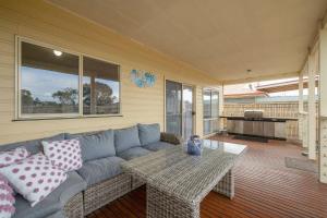 a living room with a couch and a table at Cooinda at The Cape in Cape Woolamai