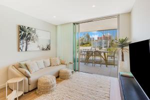 a living room with a couch and a balcony at Miles at Kirra Point 303 in Gold Coast