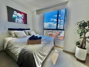 a bedroom with a bed and a large window at Loft/Apartaestudio Chapinero con piscina gym in Bogotá